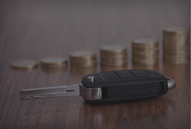 car key and stacked coins on a table